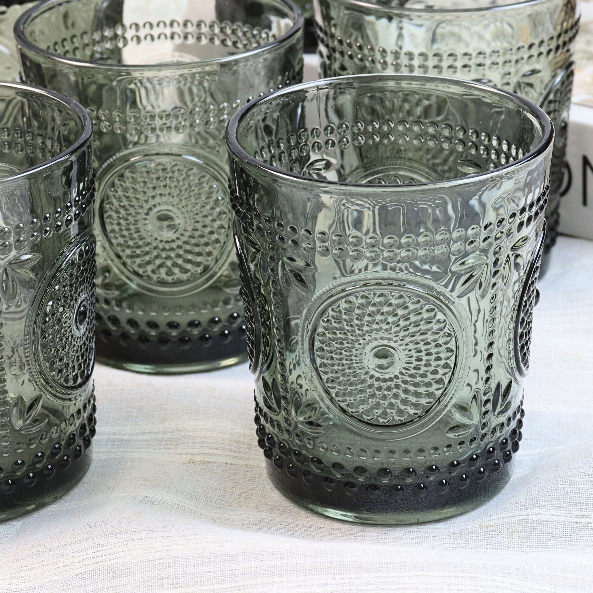 Set of textured glass tumblers on a white surface