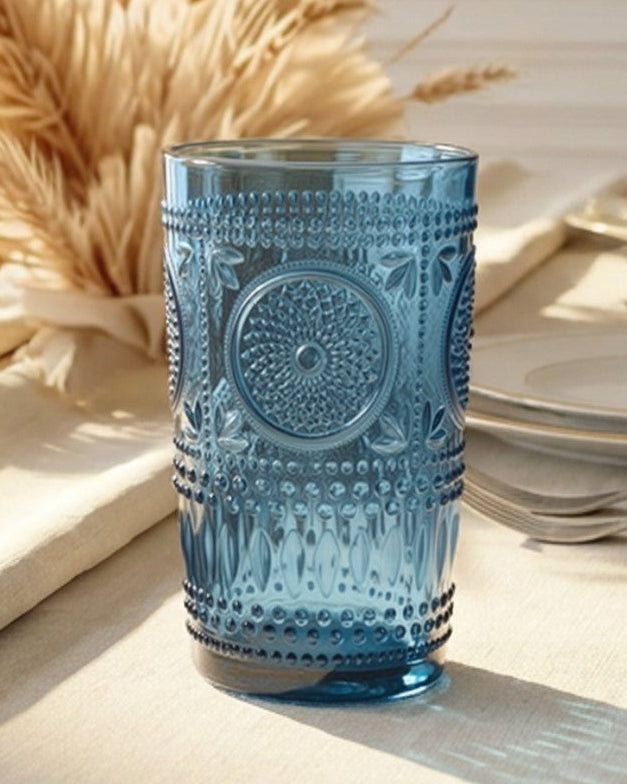 Set of blue textured glasses on a white surface with a light wooden background