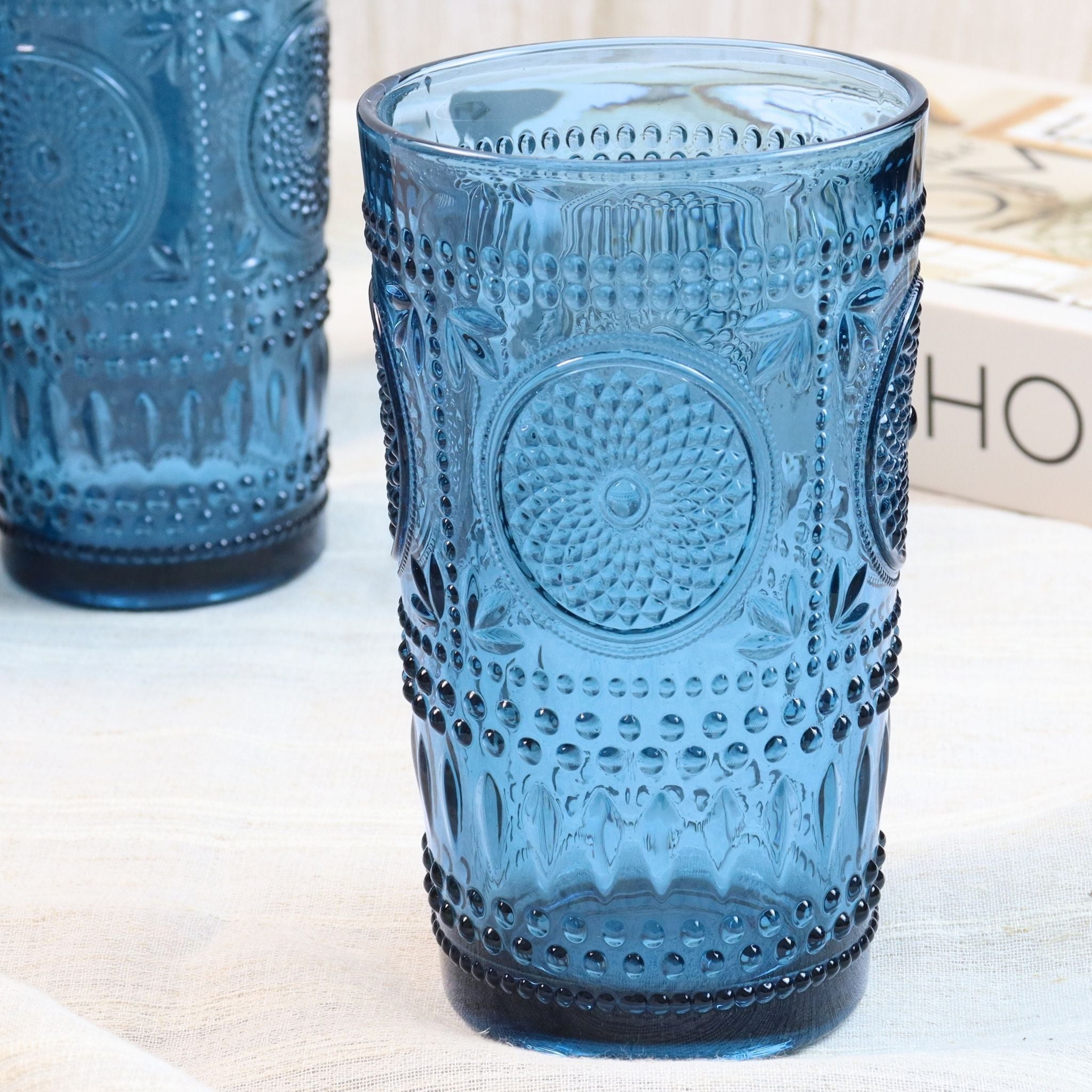 Two blue textured glass tumblers on a light surface.