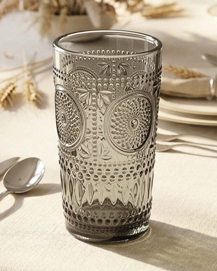 Set of six gray glass tumblers with textured design on a white surface.