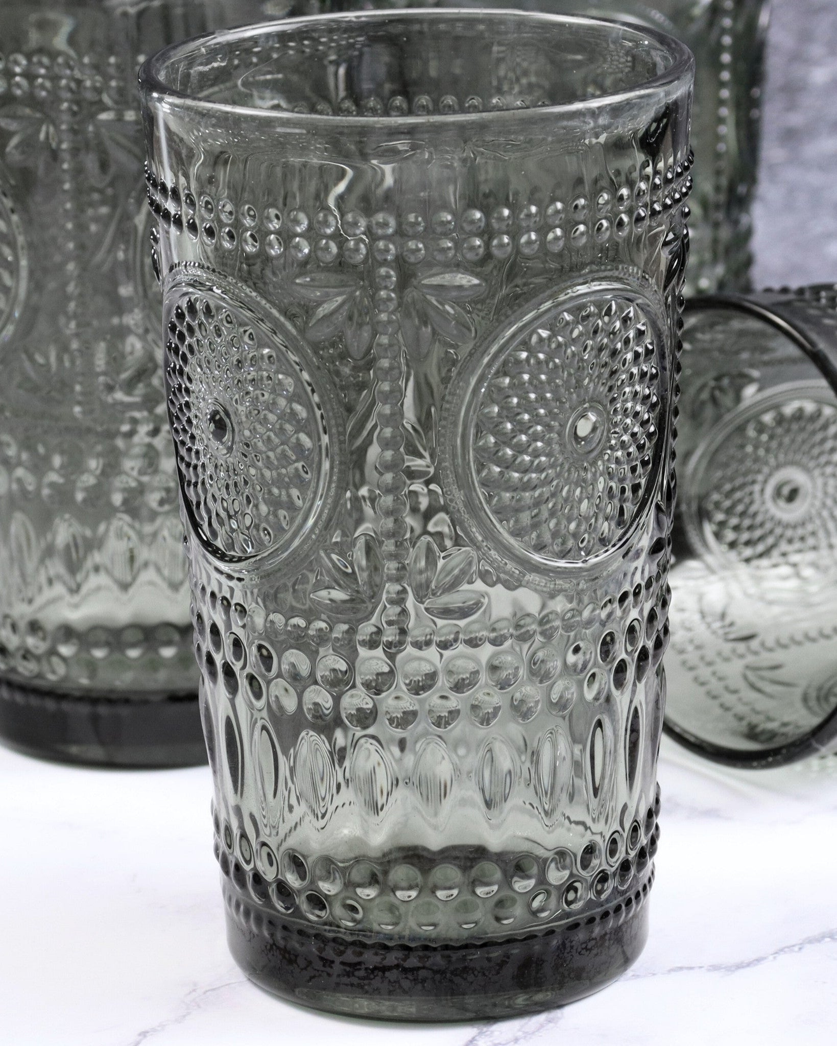 Decorative glass tumbler with textured design on a white surface