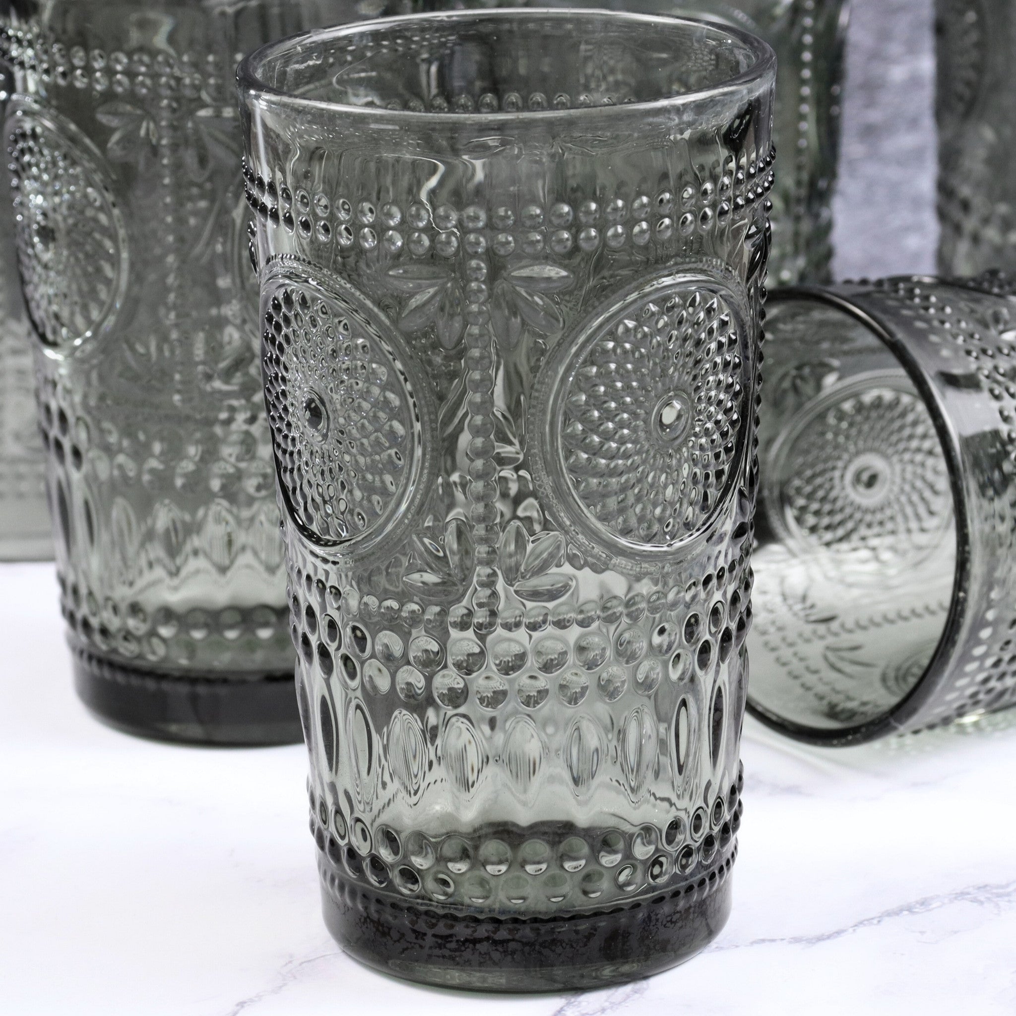 Decorative glass tumbler with textured design on a white surface