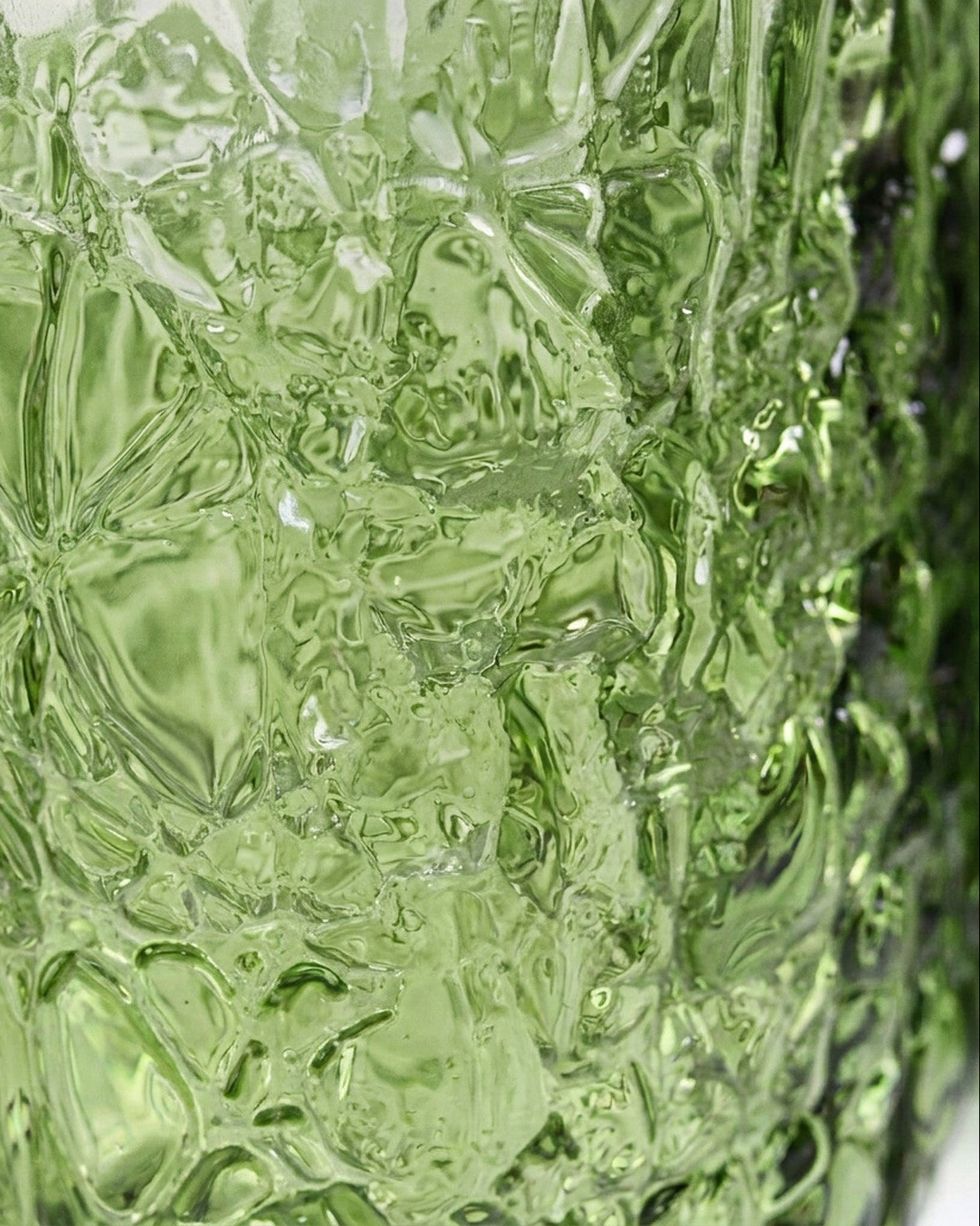 Set of green textured glass tumblers on a light background