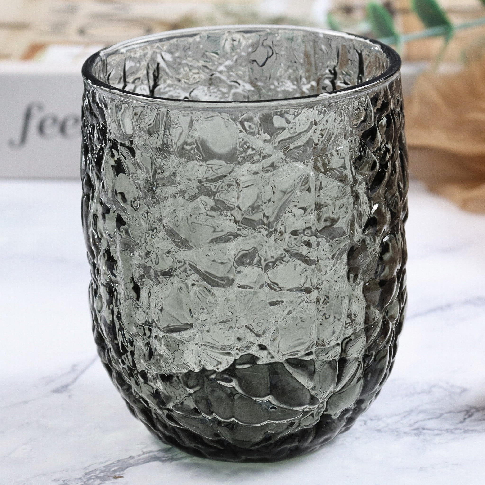 Textured glass candle holder on a marble surface
