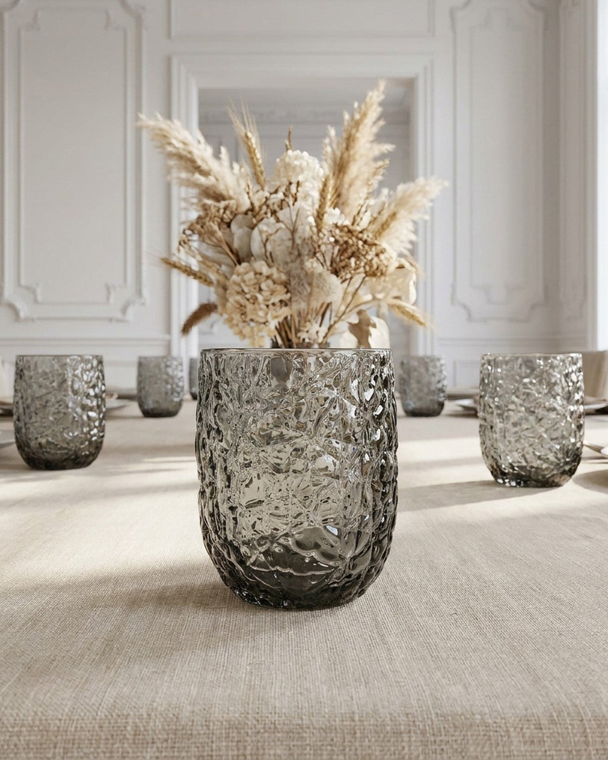 Set of six textured gray glasses on a white surface with a gray background