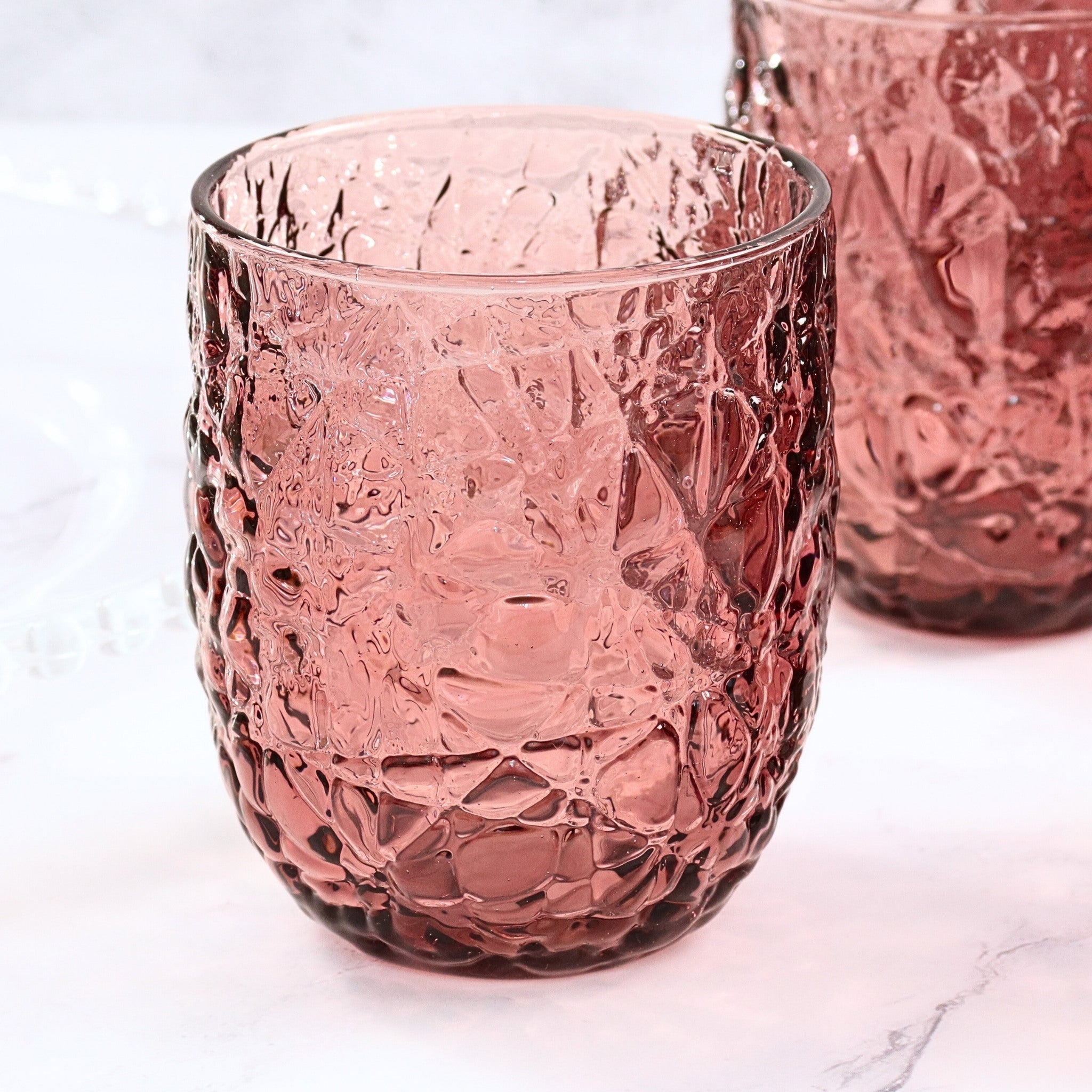 purple textured glass tumblers on a white background