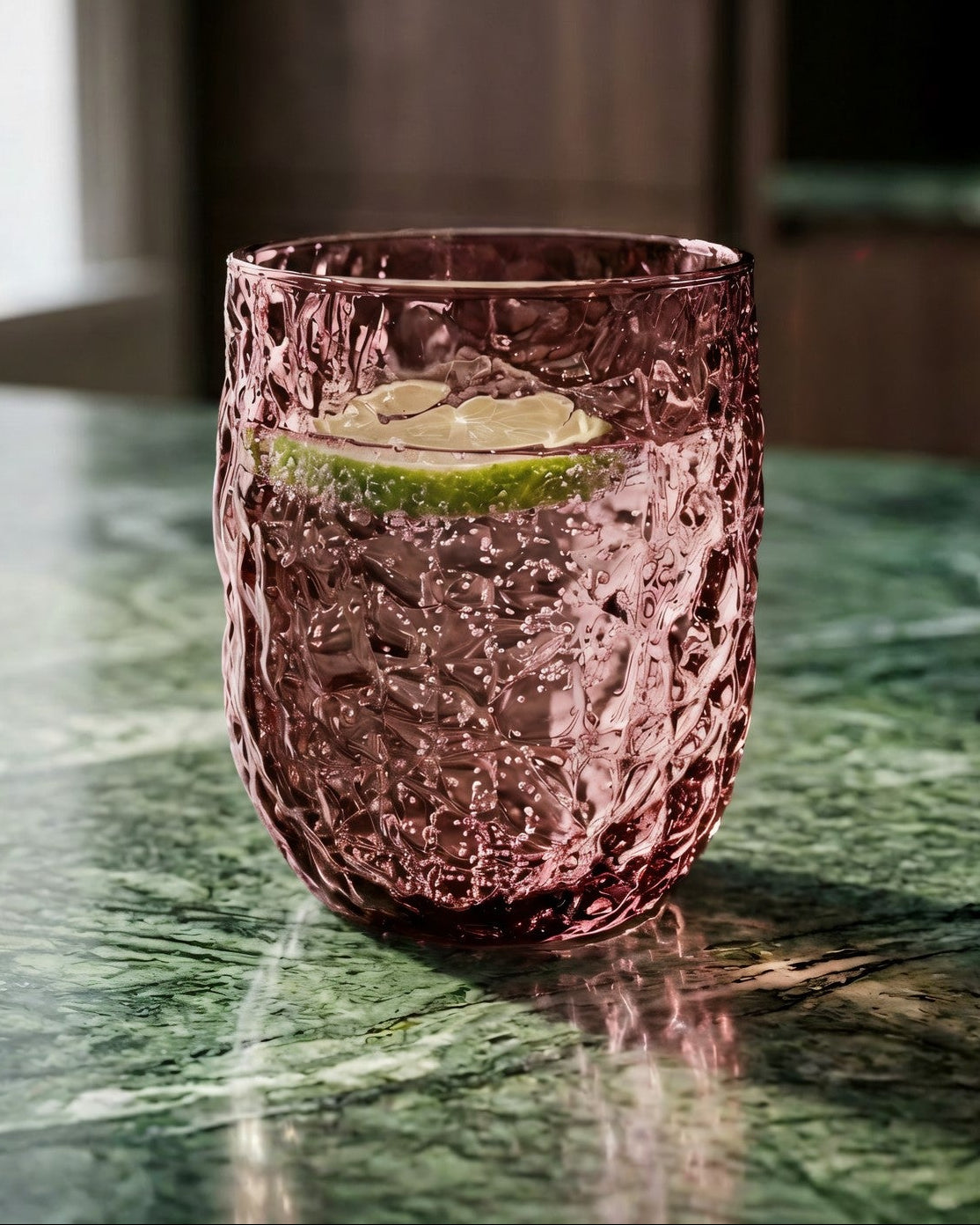 Two purple textured glass tumblers on a marble surface