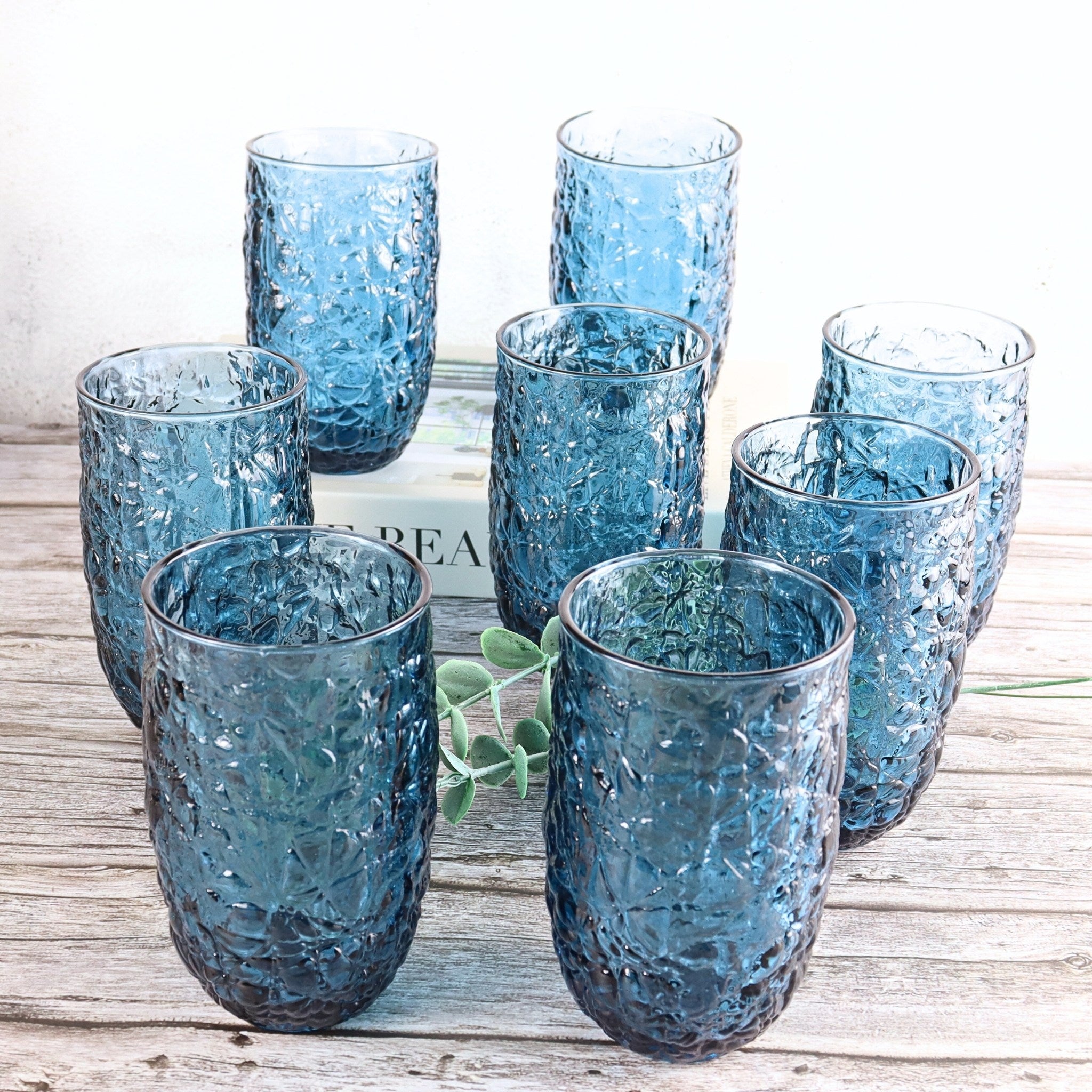 Set of blue textured glass tumblers on a wooden surface