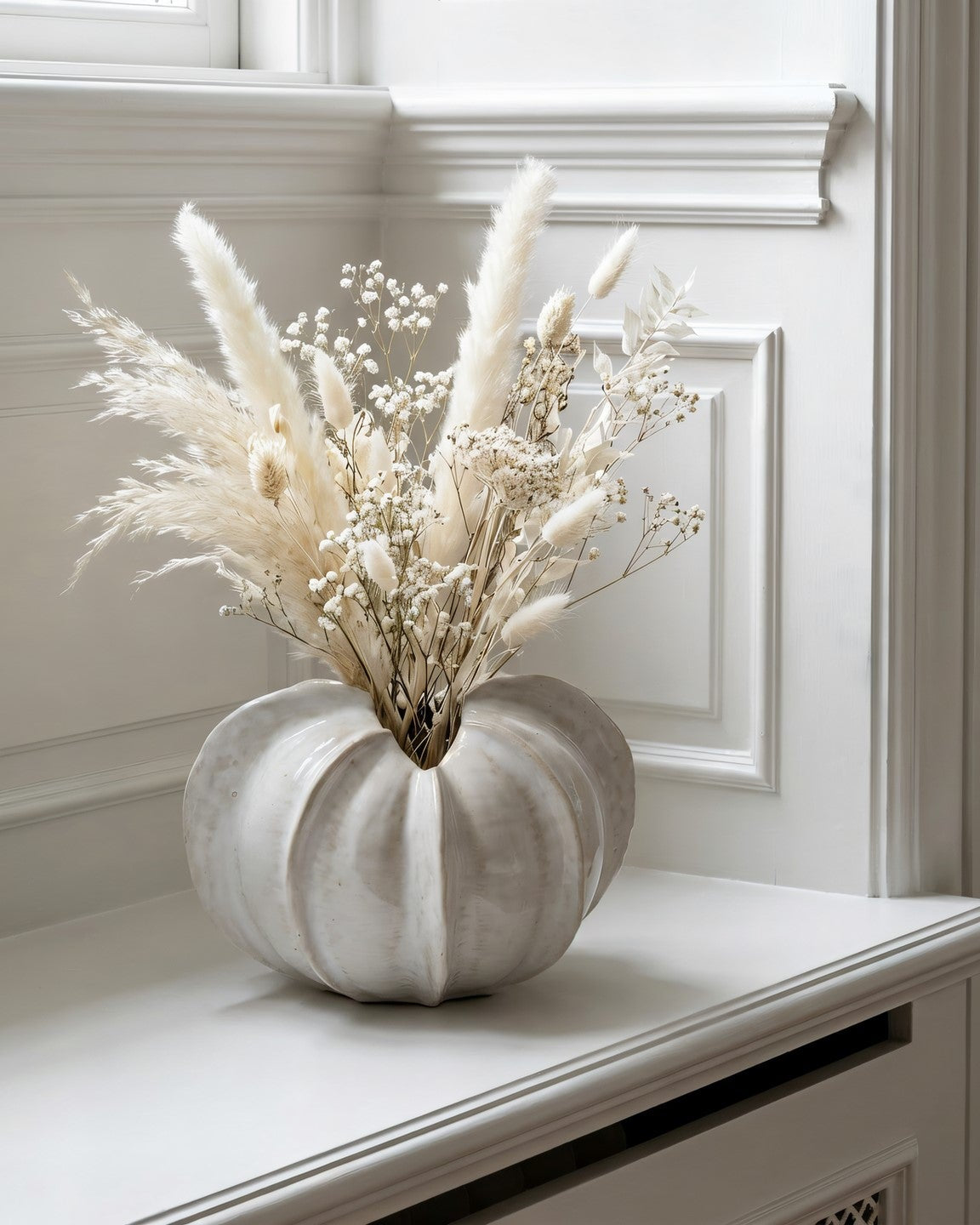Decorative pumpkin with dried flowers on a white surface