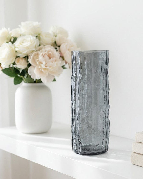 Decorative vase with white flowers on a wooden surface